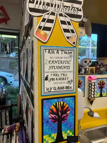 Yellow pillar with teacher sign and tree artwork